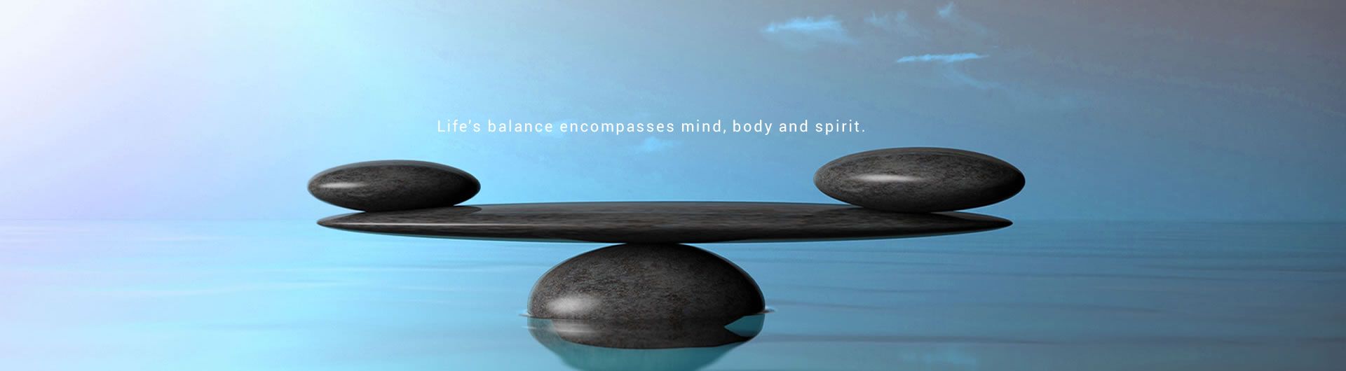 balancing stones on blue background