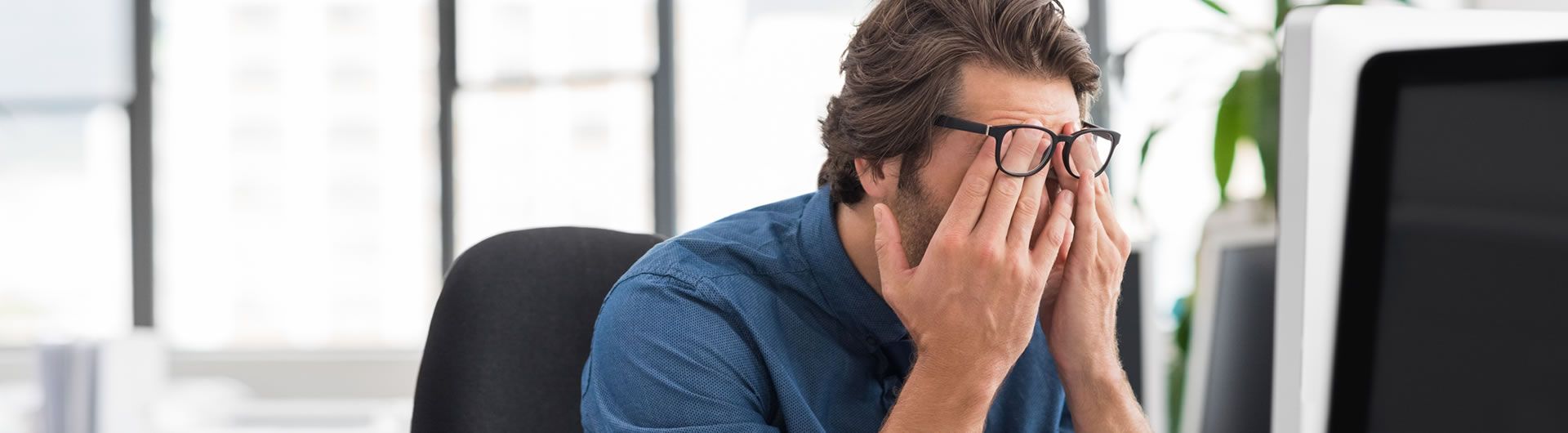 Man at computer stressed at work